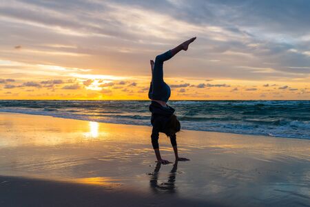 Young girl exercising on a seaside beach at sunset - barefootの写真素材