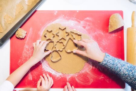 Christmas bakery. Woman making gingerbread, cutting cookies of gingerbread dough, view from above. Festive food, cooking process, family culinary, Christmas and New Year traditions conceptの写真素材