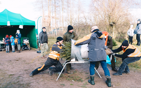 Babki, Poland - December 15, 2019; Sale of Christmas trees on a plantation in the forest - packing cut firs in foil nettingのeditorial素材