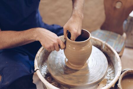 Potter making a clay vase on a potter's wheelの写真素材