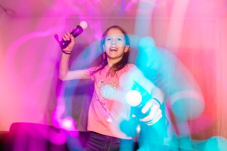 Enthusiastic teenager girl playing on a computer consoleの写真素材