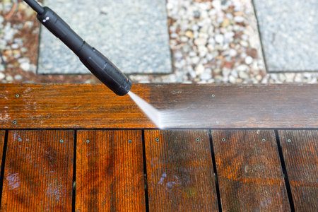 cleaning terrace with a power washer - high water pressure cleaner on wooden terrace surfaceの写真素材