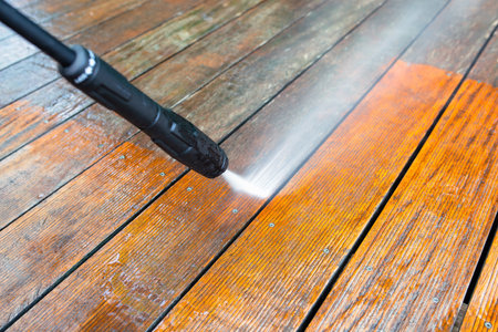 cleaning terrace with a power washer - high water pressure cleaner on wooden terrace surfaceの写真素材
