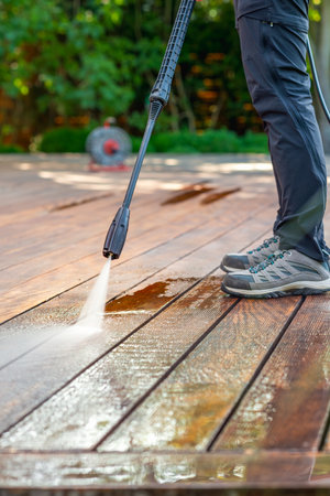 cleaning terrace with a power washer - high water pressure cleaner on wooden terrace surfaceの写真素材