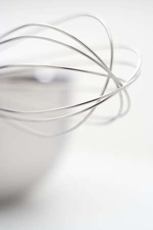 close-up of a metal kitchen whisk tip with very limited depht of field and fuzzy backgroundの写真素材