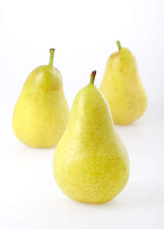 Three yellowgreen pears on bright background. Focus on front pear.の写真素材