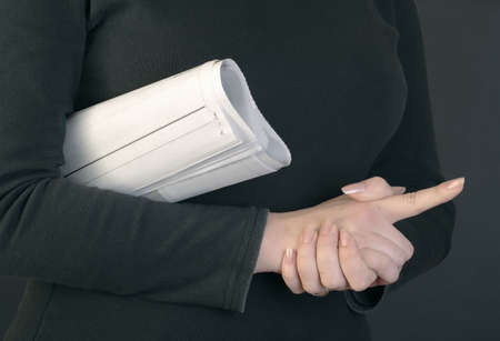 Close up of a woman hands and rolled newspaper