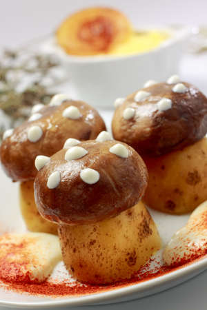 Fried button mushrooms (upper part) with boiled potatoes (lower part) stylized as fly agaric mushroomの写真素材
