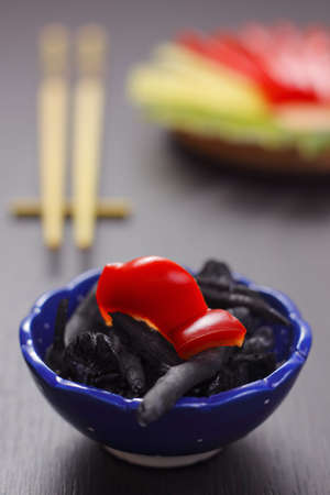 Still life with piece of sweet pepper lying on bowl with charcoalの写真素材