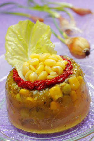 Vegetable jelly with tomato sauce, sweetcorn and lettuce on glass plate