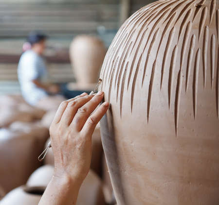 hands of Thai style pottery working on ceramic vaseの写真素材