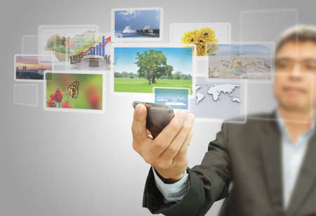 businessman hold touchscreen mobile phone with virtual imagesの写真素材