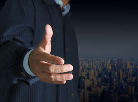 Businessman offering for handshake and city backgroundの写真素材