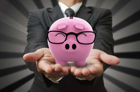 Businessman shows a piggy bankの写真素材