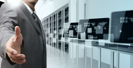 business man offers hand shake in computer centerの写真素材