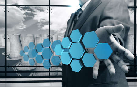 business man hand shows abstract icon with power plant backgroundの写真素材
