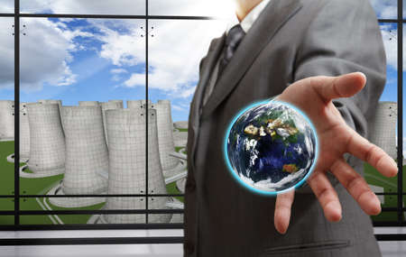 business man shows the earth with nuclear power plant background,Elements of this image furnished by NASAの写真素材