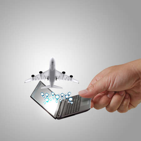 business man hand holds laptop and dream travelの写真素材