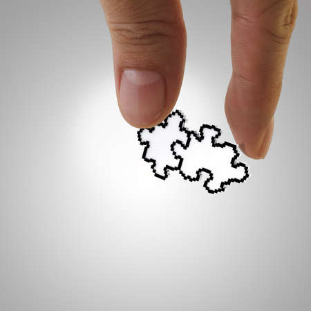 close up of fingers picking up pixel puzzles icon as partnership business conceptの写真素材