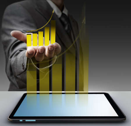 business man hand shows virtual gold graph with tablet computerのeditorial素材