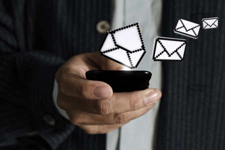 business man hand using touch screen phone and pixel e-mail icon as concept