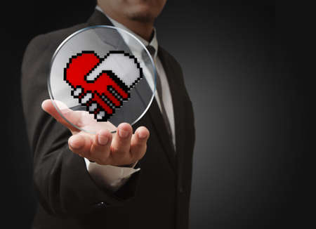 business man hand show pixel hand shake heart shaped symbol as medical technology conceptのeditorial素材