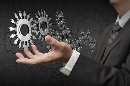 Business team cooperation with  wheels made of gears or cogs as human worker symbols の写真素材
