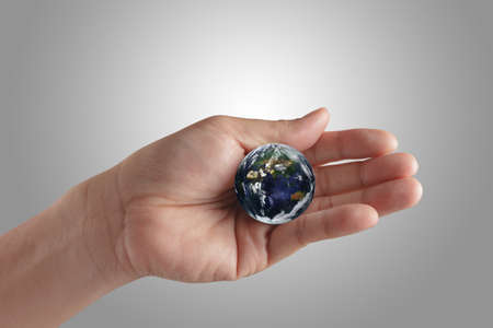 holding a glowing earth globe in his handsの写真素材