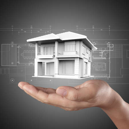 The house in hands on blue printの写真素材