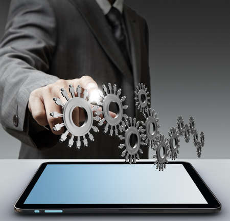 Business man show gear to success from touch screen computer Business man show gear to success from touch screen computer