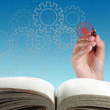 Man designing a mechanical system using old cog gear wheelsの写真素材