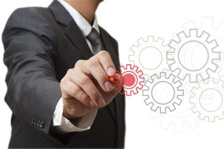 Man designing a mechanical system using old cog gear wheelsの写真素材