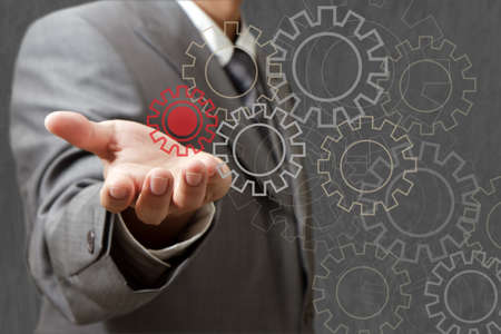 Man designing a mechanical system using old cog gear wheelsの写真素材