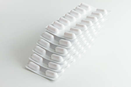 Blister stack packs of white pills with white backgroundの写真素材