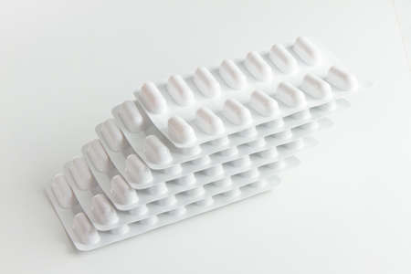 Blister stack packs of white pills with white background