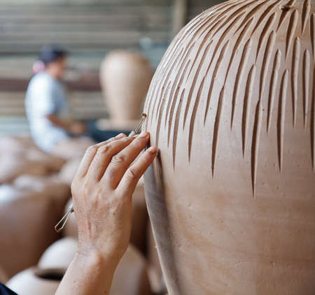 hands of a potter, creating an earthen jar on the circleの写真素材