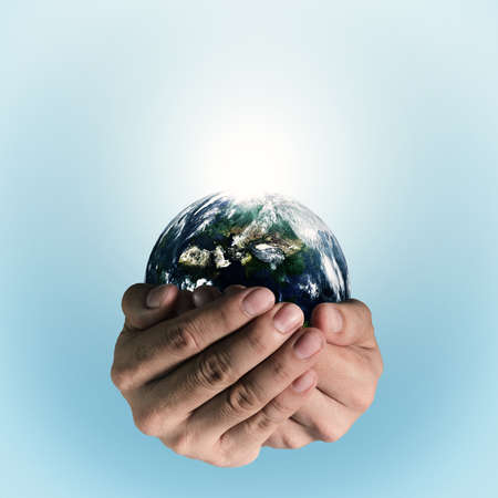 holding a glowing earth globe in his handsの写真素材