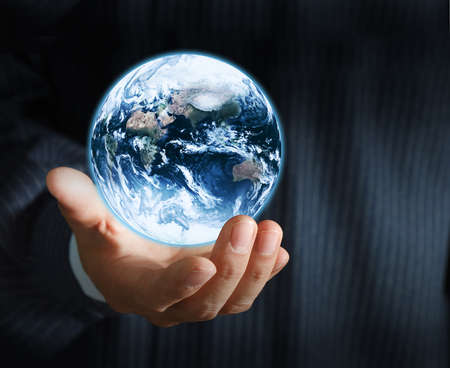 holding a glowing earth globe in his handsの写真素材