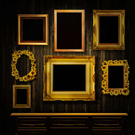 Gallery display - vintage gold frames and a chest of drawers on an old timber wall