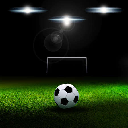 Soccer ball on grass against black backgroundの写真素材
