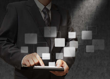 business hand holding a touch pad and virtual buttons add light beam to objectの写真素材