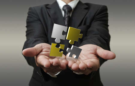business man shows 3d metallic puzzle as conceptの写真素材