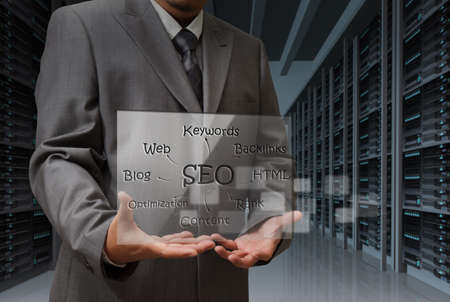 business man hand shows virtual screen of SEO diagramの写真素材