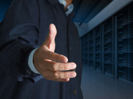 close up businessmen offer hand shake in a technology data centerの写真素材