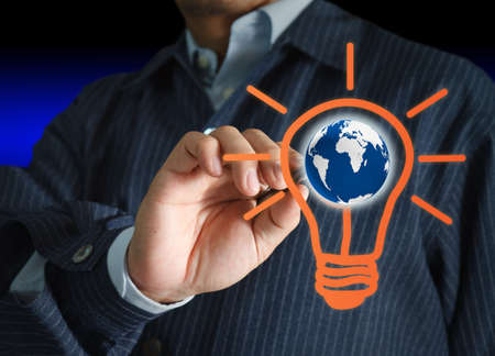 hand with a pen drawing light bulb and globeの写真素材