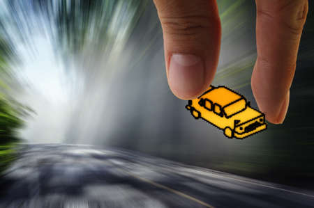 hand picks pixel car icon on the road with motion blur background as conceptの写真素材