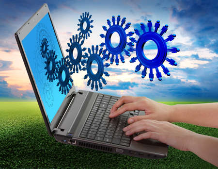 hand using laptop computer and people cogs as conceptの写真素材
