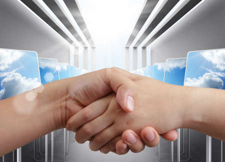 handshake with computer room backgroundの写真素材