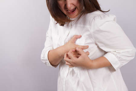woman clutching her chest. in pain, possible heart attackの写真素材