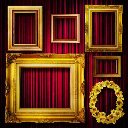 Gallery display - vintage gold frames on deep red curtain wallの写真素材